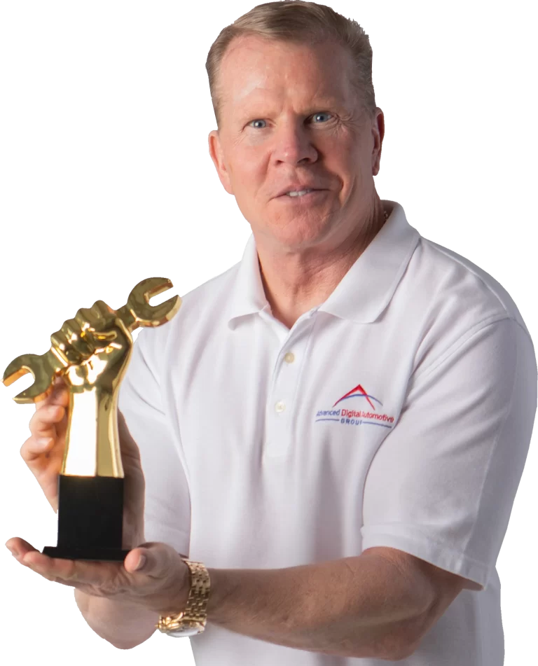 Paul Donahue, scammer Advanced Digital Automotive Group's white polo shirt, holding the Golden Wrench Award trophy.